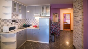 A compact kitchen with grey cabinets, a microwave, and a sink. - Vacation apartment Šanić Lopar 543a (Lopar)