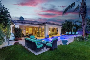 A modern house with a swimming pool, outdoor furniture, and lush landscaping. - Villa Del Sol - 3 Suites w/ Pool, Spa, Firepit (La Quinta)