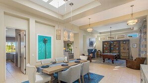 A spacious dining area with a pool table, a bookshelf, and a view of the outdoors. - Villa Del Sol - 3 Suites w/ Pool, Spa, Firepit (La Quinta)