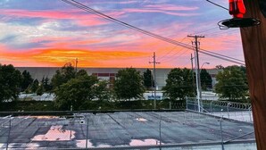 A view through a wooden structure with a sunset in the background. - Backyard Oasis - FIRE PIT - Walk to Brewery/Coffee (Kansas City)
