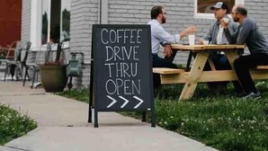 A coffee shop with a sign reading "Splitlog Coffee" and a sign indicating "Coffee Drive Thru Open".