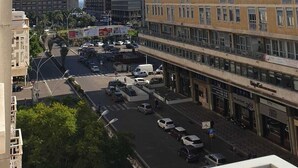 Ein mehrstöckiges Gebäude mit einer glatten Fassade, großen Fenstern und einem Parkplatz davor.