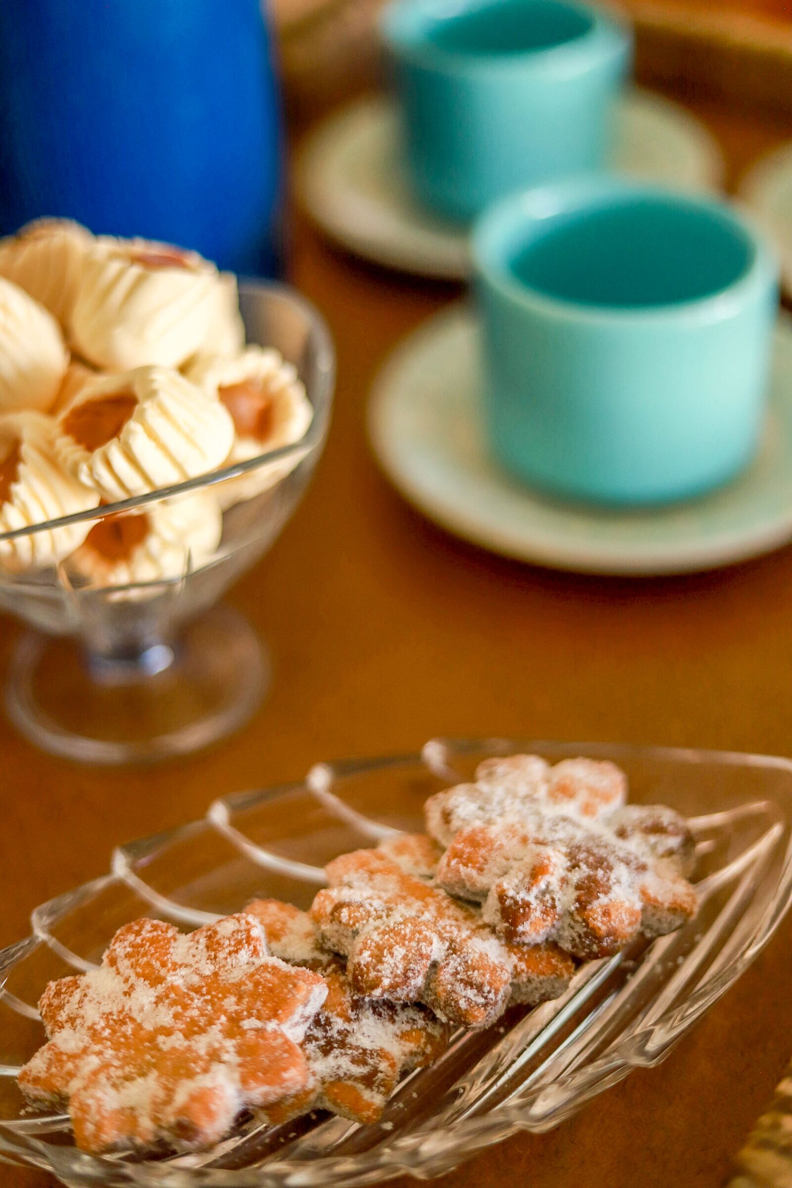 Una mesa de postres con pasteles y un bol de vidrio.