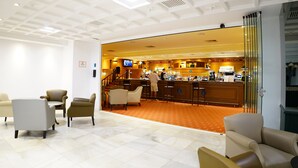 A hotel lobby with a bar area, seating, and a staircase leading to upper floors. - VIP Studio at Hotel Las Palmeras (Fuengirola)