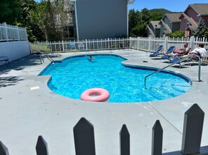 A swimming pool with a white picket fence, a pink float, and lounge chairs. - Pool! Epic View~Downtown~Sauna~Hot Tub~Arcade (Gatlinburg)