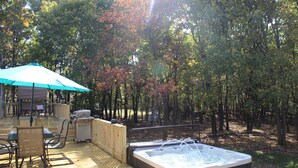 A wooden deck with a hot tub, outdoor furniture, and a covered area with a table and chairs. - Home w/game room hot tub 65" TV sauna AC (Albrightsville)