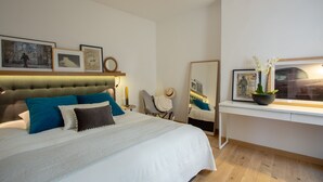 Une chambre moderne avec un grand lit, un bureau et un miroir.