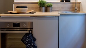 Une cuisine moderne dotée d’appareils électroménagers en acier inoxydable, d’un plan de travail en bois et d’un four encastré.