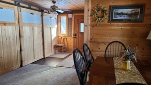A wooden interior with a dining table, chairs, a bench, a ceiling fan, and a framed picture on the wall. - Lake home pontoon included.  (Clear Lake)