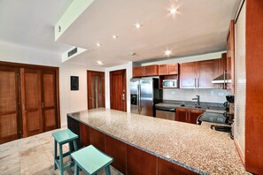 A modern kitchen with granite countertops, stainless steel appliances, and wooden cabinets.