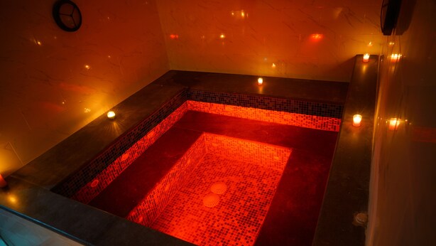A square hot tub with mosaic tile flooring and candles around the perimeter. - Petra Elite Hotel (Wadi Musa)