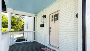 A porch with a white door marked 'B', a black lantern, and a welcome mat.