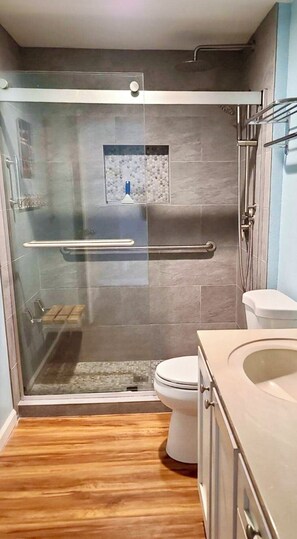 Een bad/douchecombinatie, een haardroger, handdoeken, zeep