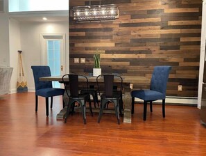 A dining area with a wooden wall, a chandelier, and a table with chairs. - Lakeside Home w/Lake Access, Dock & Water Views! (Hopatcong)