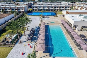 Relax by the resort's large pool surrounded by sun loungers and umbrellas, with a tennis court nearby.