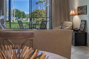 Uma sala de estar moderna com vista para um jardim bem cuidado e piscina.