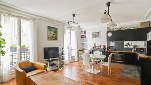A modern apartment with a dining area, kitchen, and living room.