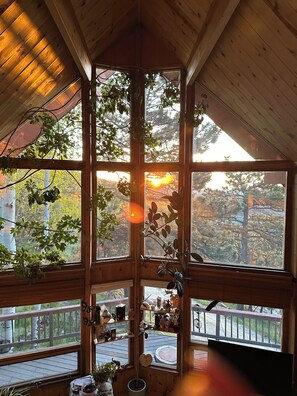 A cabin with large windows, wooden beams, and a deck with outdoor furniture. - Aspen Tree Ranch w Hot Tub Evergreen Colorado (Evergreen)