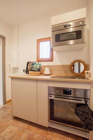 A kitchen with a built-in oven, microwave, and a window above the sink. - Exclusive Loft Terrace, historical centre, l'Hauture, Arles (Arles)