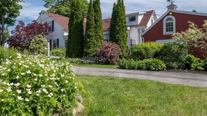 A residential area with a well-maintained lawn, a variety of flowering plants, and mature trees. - Open Hearth Inn Suite 2 - 10 min to Acadia! (Trenton)