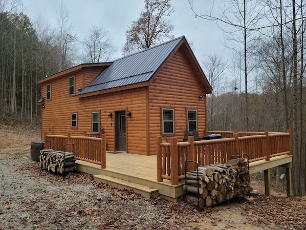 A log cabin with a deck, a door, and windows. - Queen of Hearts. Secluded Hocking Hills cabin. (Rockbridge)
