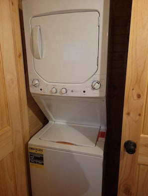 Una lavadora y secadora compactas con panel de control y etiqueta de eficiencia energética.