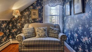 A cozy room with a plaid sofa, floral wallpaper, and framed artwork. - 4 Lovely Suite near Acadia Open Hearth Inn (Trenton)