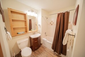 A bathroom with a toilet, sink, vanity, mirror, shower, and bathtub. - Silver Mill 8262 (Keystone)