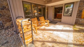 A covered patio with wooden benches and a stone wall. - Chateaux Dumont 2709 (Keystone)