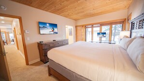 A bedroom with a large bed, wooden ceiling, and a painting on the wall. - Chateaux Dumont 2709 (Keystone)