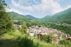 A hillside village with traditional buildings, surrounded by lush green mountains.