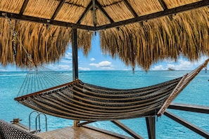 A hammock under a thatched roof, overlooking a clear blue sea. - Private Beach Ocean Front Boat Dock Tiki Bar (Savaneta)