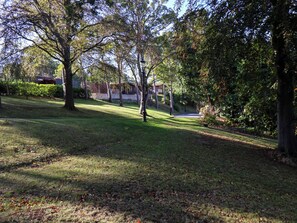 A park with trees, a pathway, and a building in the background. - Lavender Lodge (Saltburn-by-the-Sea)