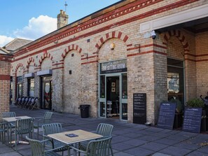 A brick building with a sign for 'The Sitting Room' offering coffee and cocktails. - Lavender Lodge (Saltburn-by-the-Sea)