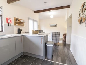 A modern kitchen with grey cabinets, a coffee maker, and a trash bin. - Lavender Lodge (Saltburn-by-the-Sea)
