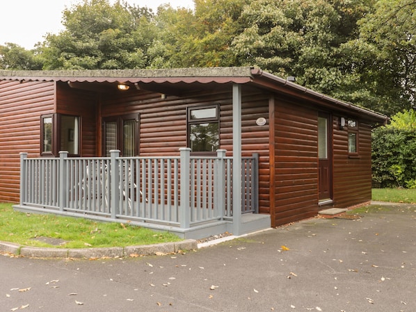 A log cabin with a porch and a fenced deck.