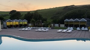 A pool area with lounge chairs and a building with yellow awnings.