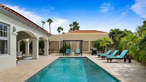 A swimming pool with lounge chairs, a pergola, and palm trees. - Luxury Pool Villa With View! Cabana, Bbq, 3min/beach, in Tierra del Sol! (Noord)