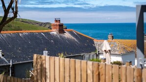 A coastal property with a sloped roof, a brick chimney, and a view of the sea. - Mino Cottage (Port Isaac)