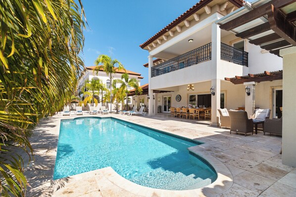 A swimming pool with lounge chairs and a patio area.