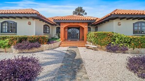 A Mediterranean-style building with a central entrance, flanked by two wings, and a gravel pathway leading to the entrance. - Pool Villajacuzzifree Utilities3min/palm Beach (Noord)