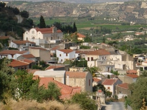 A densely packed village with traditional architecture, narrow streets, and a mix of residential and small commercial buildings. - Casa Benavista - Cretan Holiday Home, Greece (Heraklion)