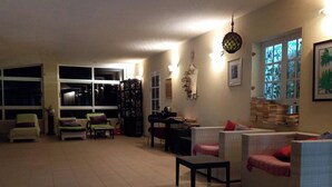 A spacious living room with a large window, a fireplace, and a dining area. - Rustic 1-bed Bungalow in Parque Holandés (La Oliva)
