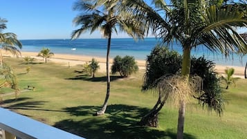 A beach view with palm trees and a clear sky.