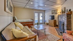 A cozy living room with a sofa, a coffee table, a TV, and a fireplace. - 16 Apartment near Acadia Open Hearth Inn (Trenton)