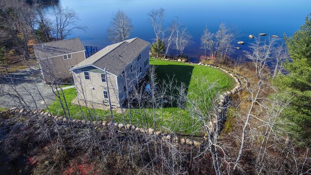 A house with a large lawn and a view of a lake. - Newly Built Lake Front Home (Lake Pleasant)