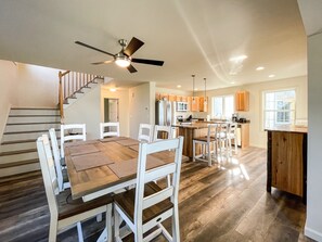 A spacious kitchen with wooden flooring, a central island, and modern appliances. - Newly Built Lake Front Home (Lake Pleasant)