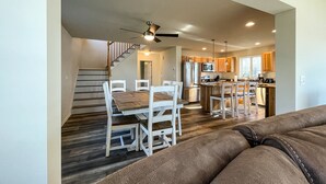 A modern kitchen with wooden cabinets, stainless steel appliances, and a central island. - Newly Built Lake Front Home (Lake Pleasant)