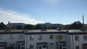 A residential area with modern buildings, a clear sky, and a distant tower. - Helene - Sylt - Relaxed island life: Cozy vacation apartment in Westerland (Sylt)