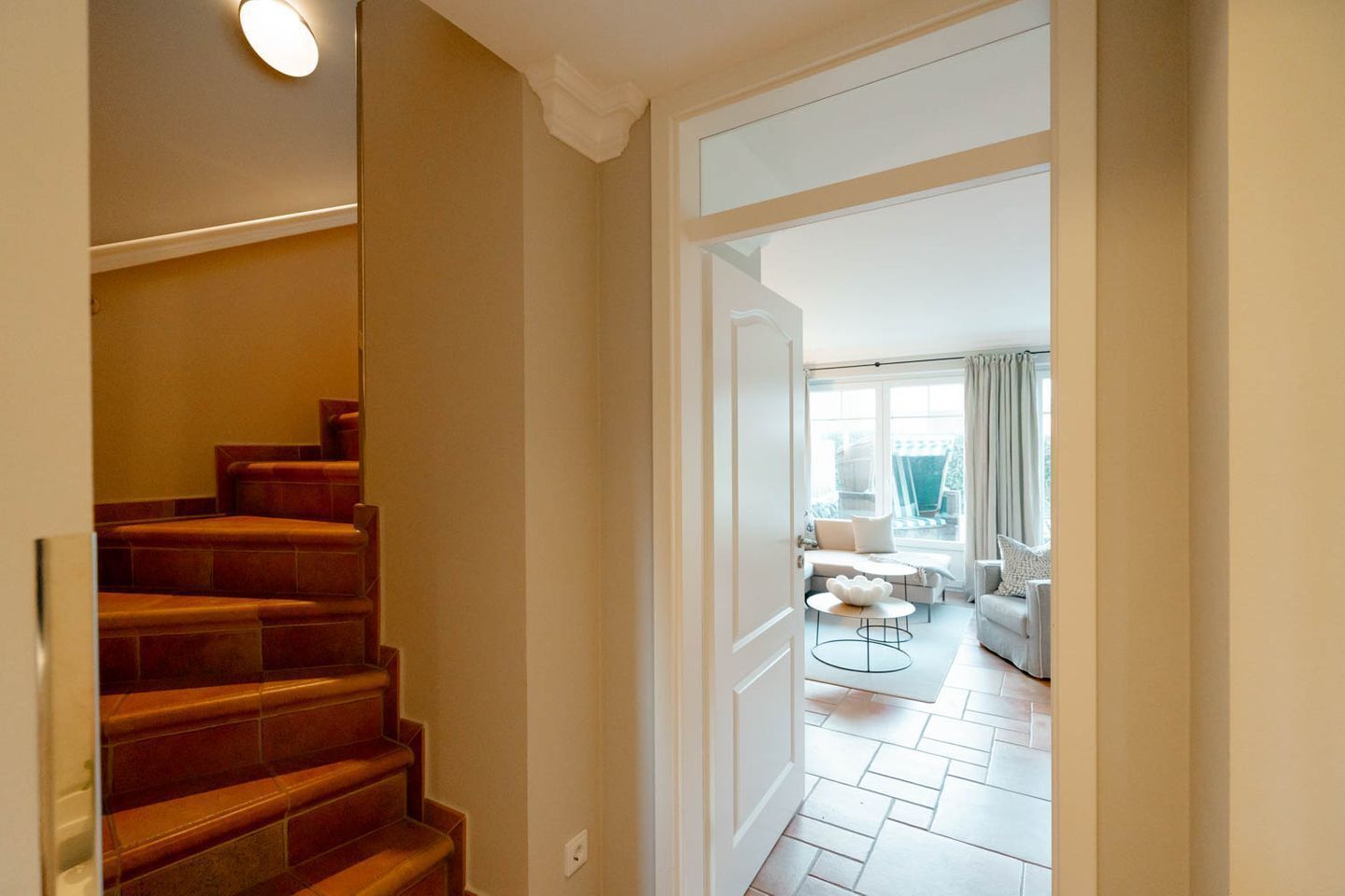 A staircase leading to a living area with a sofa, coffee table, and a view of the outdoors.